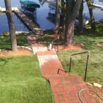 brick walkway that leads down to a lake shore