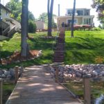 brick walkway from house to dock on a lake
